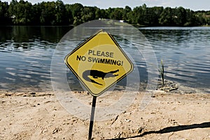 No swimming sign against the waves of lake