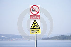 No swimming sign in motorised craft area at beach and sea