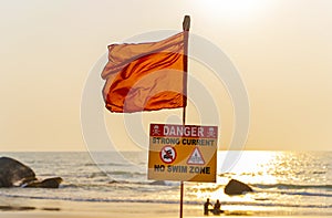 No swimming sign with red flag on the beach of Goa