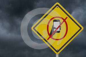 No texting or cell phone while driving symbol on warning road sign