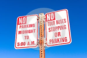 No Tour Buses stopping or parking road sign and No Overnight Parking sign