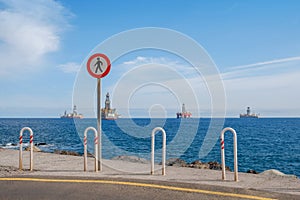 No trespass sign at end of road with ocean background, photo