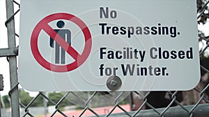 no trespassing facility closed for winter sign with illustration of crossed out