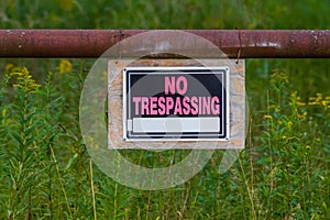 No Trespassing or Hunting sign posted for rural wooded property.
