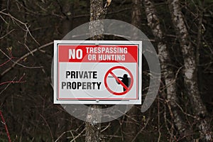 No Trespassing or Hunting sign posted for rural wooded property during spring