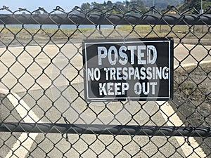 No Trespassing Keep Out sign along the fence