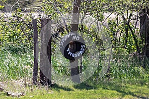 No Trespassing tire sign on barb wire fence