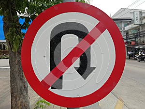 The No U-turn sign is on the sidewalk.