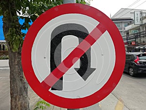 The No U-turn sign is on the sidewalk.