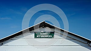 No vacancies sign set against deep blue sky