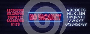 No vacancy neon sign on brick wall background.