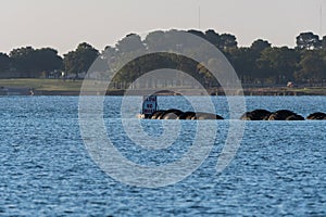 No wake sign at the end of a rubber tire breakwater on a lake