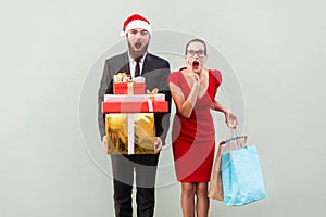 No way! Amazed bearded man in red hat and woman in red dress, ho