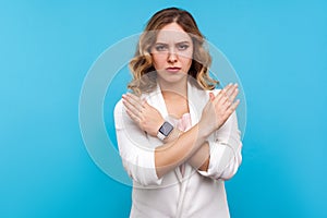 No way, never again. Portrait of determined serious woman crossing hands on chest, gesturing x sign. blue background