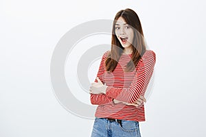 No way, are you telling truth. Amazed and surprised attractive caucasian female student in striped clothes, holding