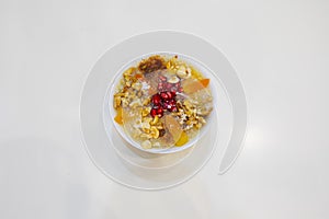 Noah`s pudding in white bowl. The dried fruits, legumes and cereals are made with wheat and sugar. It is decorated with walnut, dr