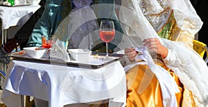 noble couple from Venice wearing old clothes from the last century while drinking an alcoholic spritz at the alfresco table photo