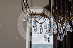 Noble and luxurious crystal chandelier light. Closeup crystal pendants of the chandelier, blur background, glamour background with