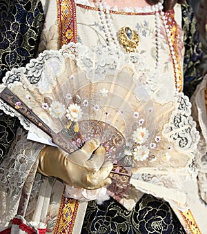Noble woman with the luxurious dress and the fan on her hand