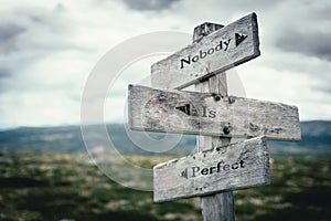 Nobody is perfect text on wooden rustic signpost outdoors in nature/mountain scenery
