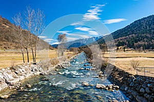 Noce River surrounded by snow-capped mountains Italian Alps Dolomities