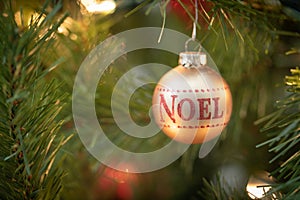 Noel Written on Christmas Ornament Hanging on Tree
