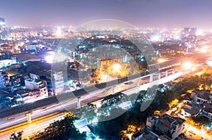 Noida metro station at night against the cityscape