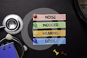 Noise Induced Hearing Loss text on Sticky Notes. Top view isolated on black background. Healthcare/Medical concept