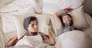 Noise, sleeping and snoring husband with a frustrated wife in bed, annoyed and uncomfortable. Young couple with problem