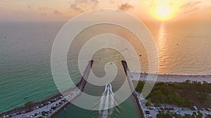 Nokomis beach ocean inlet with sailing boats and North and South Jetty in Sarasota county, USA at sunset. People