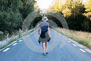 Nomad adventurer in camo hat walks road