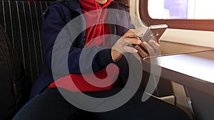 Nomad digital man hand with smartphone which he is a freelance working a vacation with laptop in the train at the morning