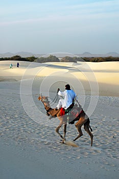 Nomad riding a camel in the desert photo