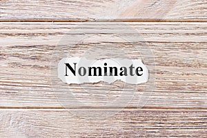 NOMINATE of the word on paper. concept. Words of NOMINATE on a wooden background photo