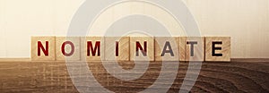 Nominate word on wooden cubes. Concept of words to put forward a candidat for voting or election