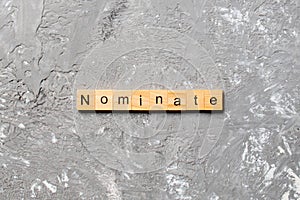 Nominate word written on wood block. nominate text on table, concept photo