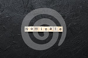 nominate word written on wood block. nominate text on table, concept photo