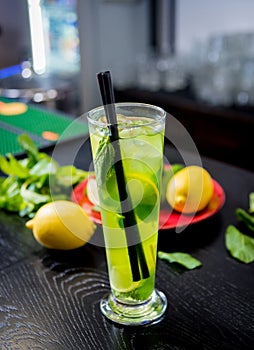 Non alcoholic cocktail with lime and mint at wooden bar counter. photo