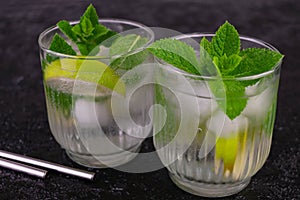 Non-alcoholic mojito with lime on a black background. Refreshing summer drink. Close-up background.