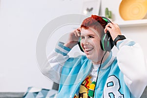 Modern young woman taking off her helmets on the living room sofa photo