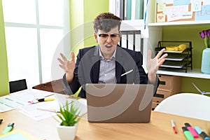 Non binary man business worker stressed shouting to laptop at office