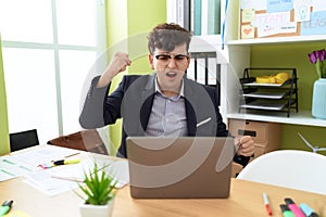 Non binary man business worker stressed shouting to laptop at office