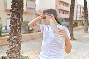 Non binary man using handfan suffering for hot at park