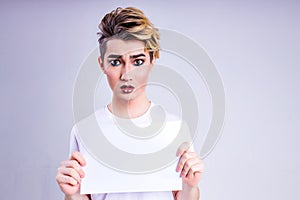 non binary portrait of asian man with luxurious blonde hair and gorgeous make-up in white wall studio background show