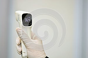 Non contact infrared forehead digital thermometer held by a medical personnel with right hand