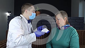 Non-contact thermometer. Doctor measures the body temperature of a senior woman. Therapist examines a woman who complains of fever