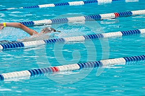 Non-identifiable swimmer in outdoor swimming pool