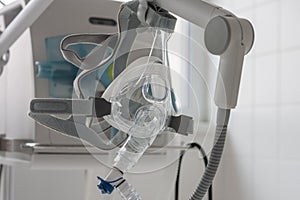 Non-invasive ventilation face mask, on background medical ventilator in ICU in hospital