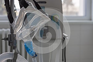 Non-invasive ventilation face mask, side view, on background medical ventilator in ICU in hospital photo