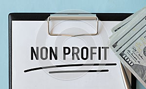 Non Profit text concept on notebook with office tools and paper.Business concept